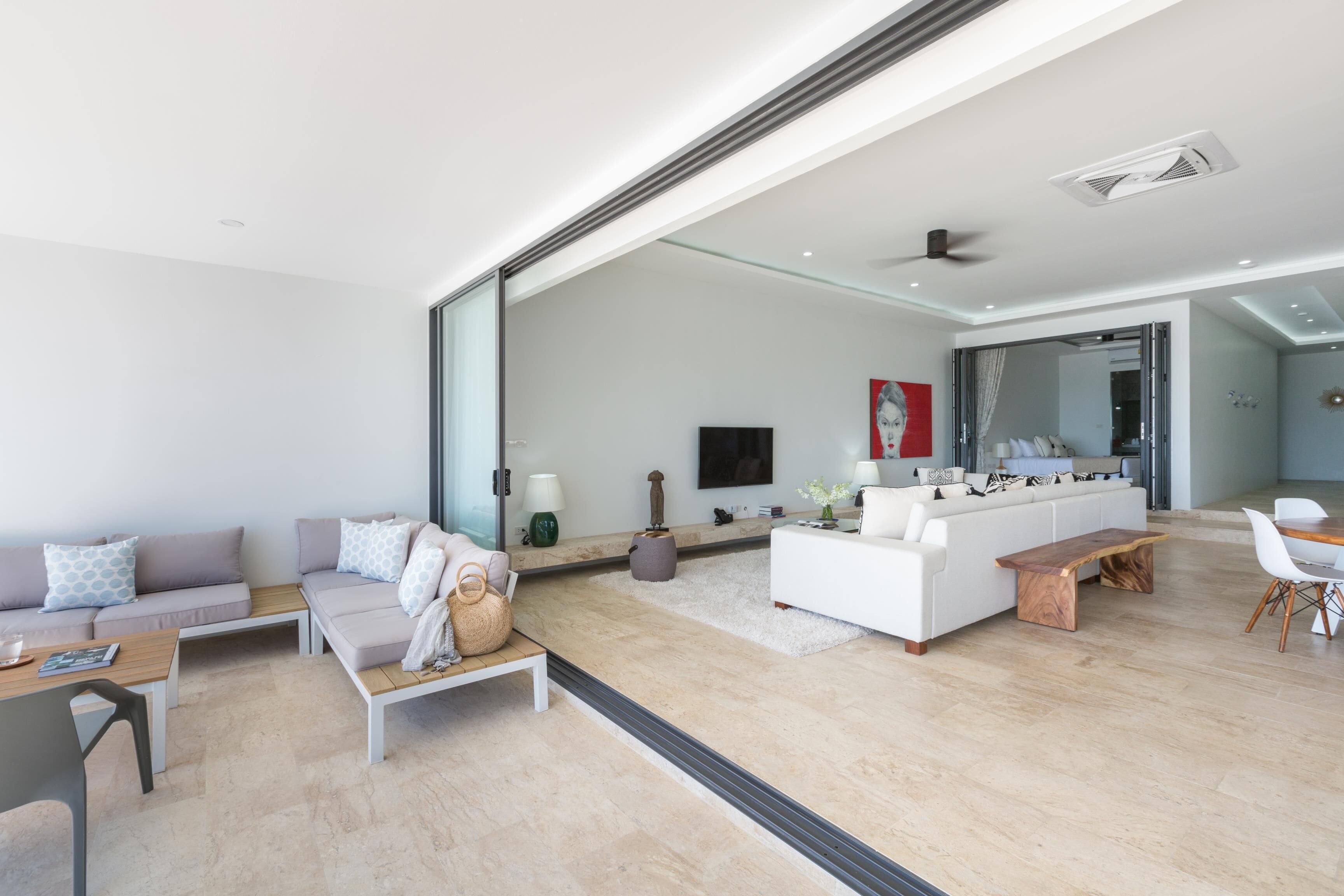 Una sala de estar moderna con un sofá, una mesa de centro y una zona de comedor con sillas.
