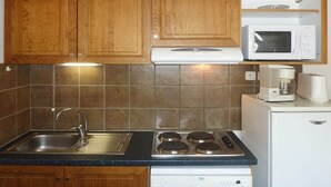 A kitchen with wooden cabinets, a stainless steel sink, a microwave, a coffee maker, and a dishwasher. - Superb 10 pax duplex with pool and jacuzzi in Les Orres 1800 (Les Orres)