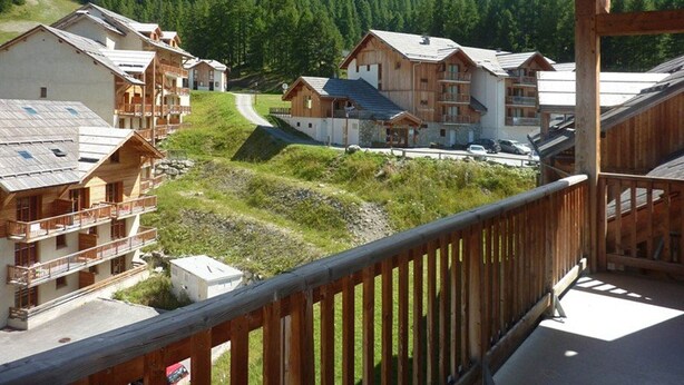 A mountain lodge with multiple wooden buildings, a ski lift, and a view of a forested mountain range. - Superb 10 pax duplex with pool and jacuzzi in Les Orres 1800 (Les Orres)