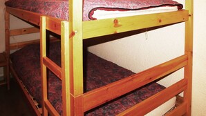 A bunk bed with a patterned mattress and a wooden frame. - Ski-in/ski-out studio for 4, Place Emile Hodoul (Les Orres)