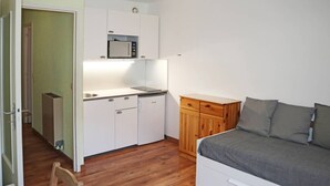 A compact room with a kitchenette, a bed, and a wooden cabinet. - Studio for 4 in central Les Orres, near slopes (Les Orres)