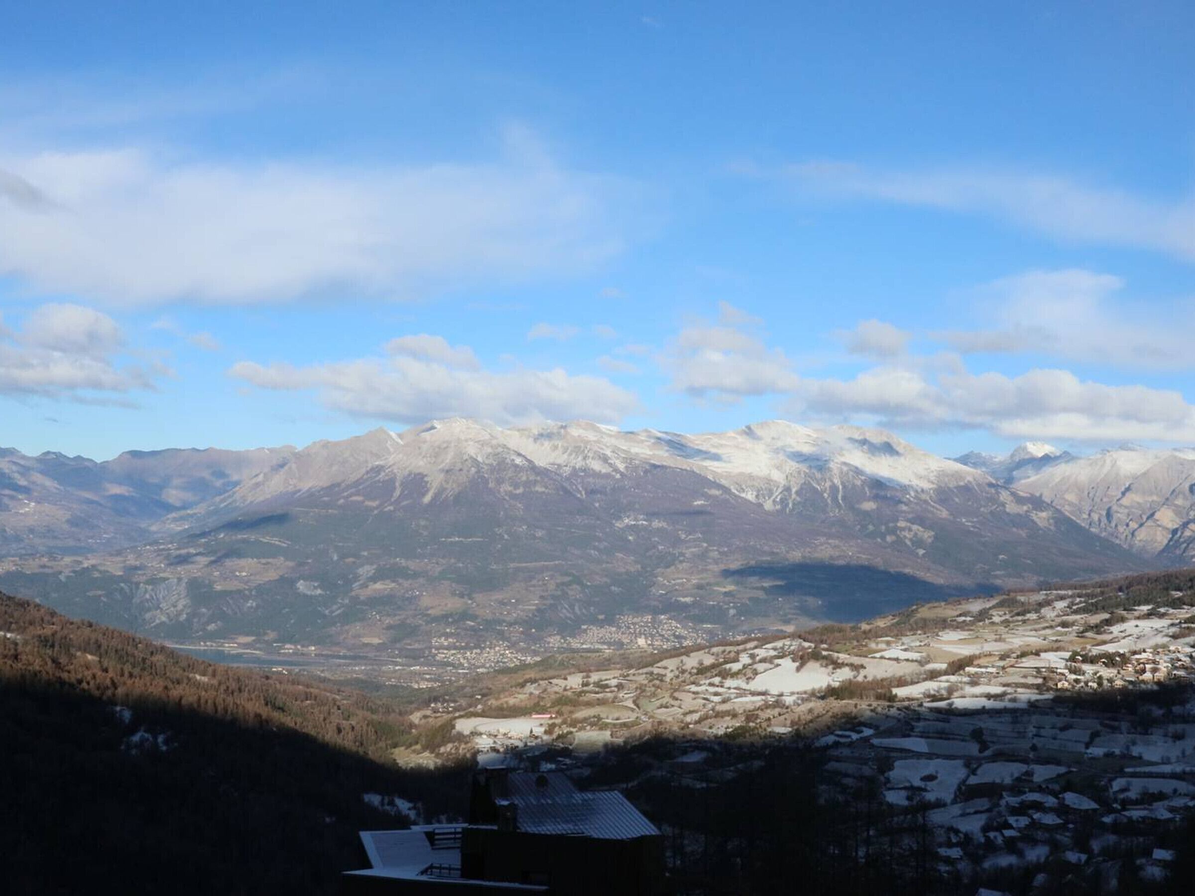 Eine Berglandschaft mit schneebedeckten Gipfeln und einem Tal darunter.