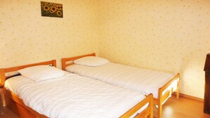 A small, single-room with two wooden beds, a wooden floor, and a wall with a sunflower painting. - Spacious 2-room apartment for 6 in the center with balcony, washer (Les Orres)