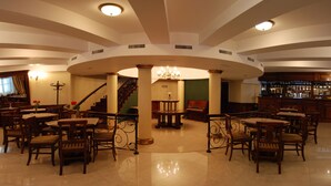 A spacious lobby with a grand staircase, a piano, and a bar area. - Hotel Gallant (Sibiu)