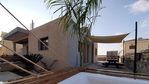 A modern building with a patio area, including a wooden deck and a picnic table.