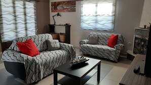 A living room with two patterned sofas, a coffee table, a lamp, and a painting on the wall.