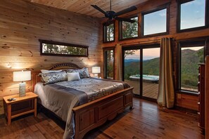 Master bedroom has wide view of mountains and easy access to hot tub, king bed, tv and private bath