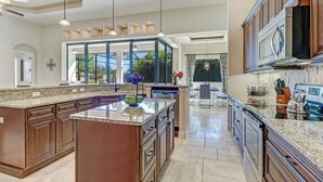 A spacious kitchen with granite countertops, stainless steel appliances, and a large island.