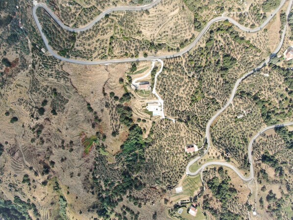 An aerial view of a winding road through a hilly landscape with sparse vegetation and a few buildings. - Pure privacy with incredible sea views (Gasperina)