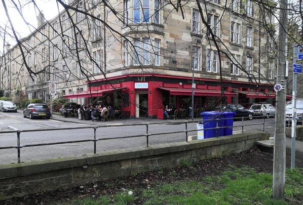 A building with a red awning, a sign for 'Victoria Hotel,' and a street in front. - Edinburgh Marchmont Meadows Flat. (Edinburgh)