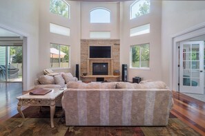 Un salón amplio con un sofá modular grande, una chimenea y un televisor.