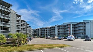 A multi-story parking lot with several cars and a tow truck. - Oceanfront Escape - Private Beach Access – Pool – Spacious Balcony – Sleeps 6 (North Topsail Beach)