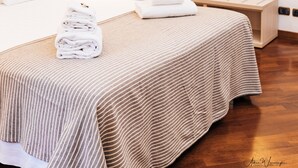 A hotel room with a large bed, a bedside table, a mirror, and artwork on the walls. - Magik Rooms (Rome)