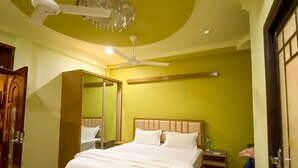 A bedroom with a bed, a ceiling fan, a mirror, a nightstand, and an air conditioning unit. - Scuba Residence (Fuvahmulah)