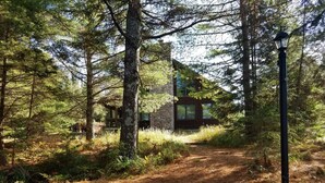 A forested area with a stone building and a path leading to it. - Piper`s Point on Lake Julia (Hiles)