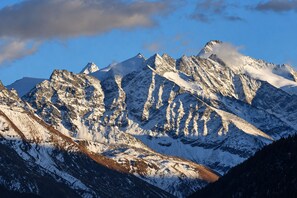 Eine Bergkette mit schneebedeckten Gipfeln und blauem Himmel.