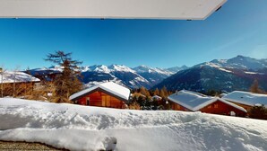 Un paysage de montagne enneigé, avec des chalets en bois.