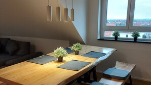 Un comedor moderno con una mesa de madera, bancos y lámparas colgantes.