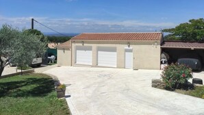 A building with a tiled roof, a covered garage, and a paved driveway. - THE QUIET HOUSE BETWEEN SEA AND MOUNTAIN (MARCORIGNAN)