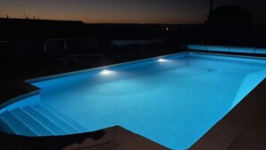 A swimming pool at dusk with a dark sky in the background. - THE QUIET HOUSE BETWEEN SEA AND MOUNTAIN (MARCORIGNAN)