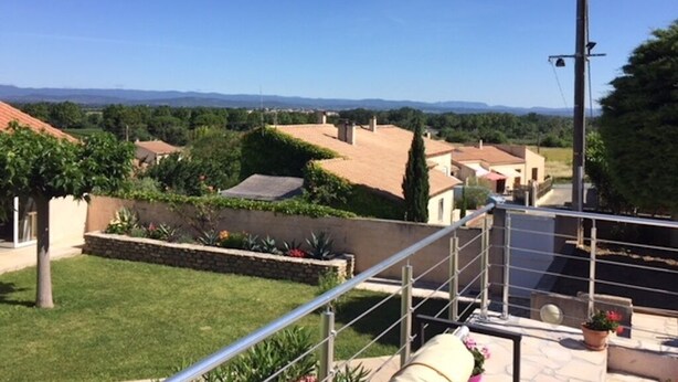 A residential area with houses, a clear blue sky, and a metal railing. - THE QUIET HOUSE BETWEEN SEA AND MOUNTAIN (MARCORIGNAN)