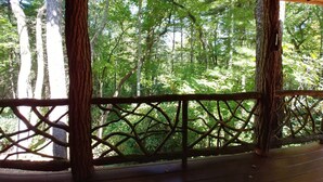 Una terraza de madera con vista a un bosque frondoso.