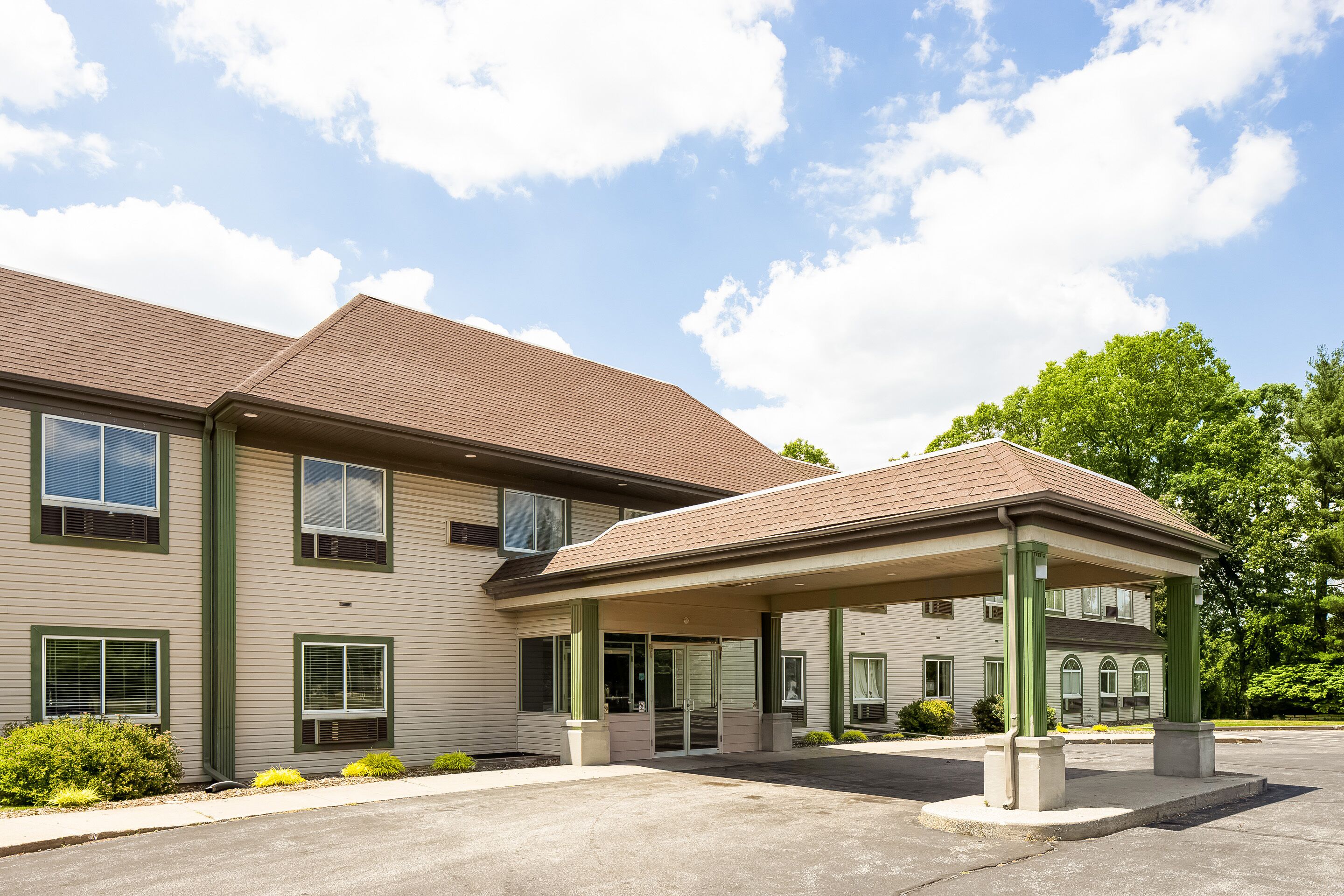 A two-story building with a covered entrance and a parking lot.