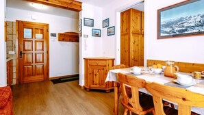 Una habitación acogedora con muebles de madera, una mesa de comedor lista para el desayuno y un cuadro grande en la pared.