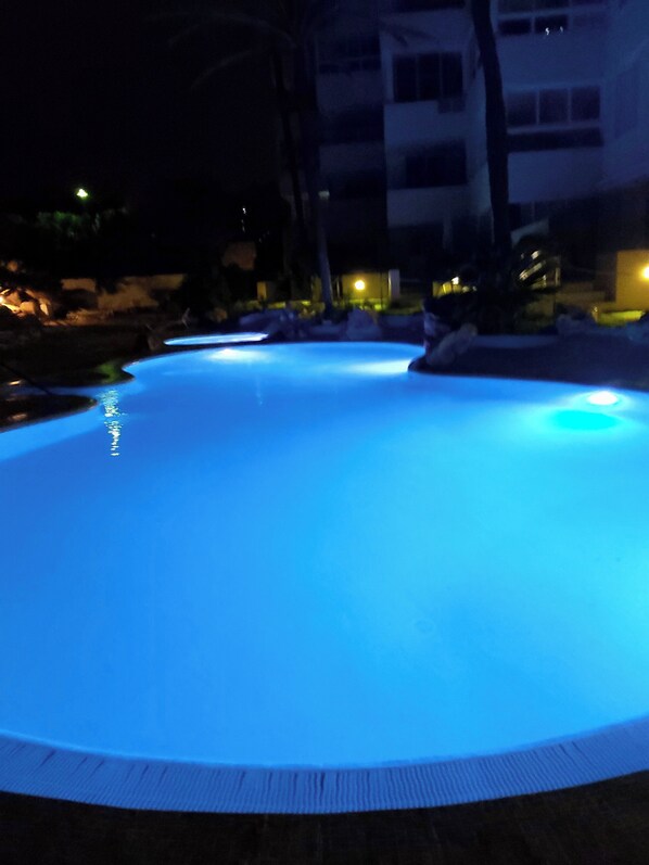 A swimming pool at night with illuminated edges.