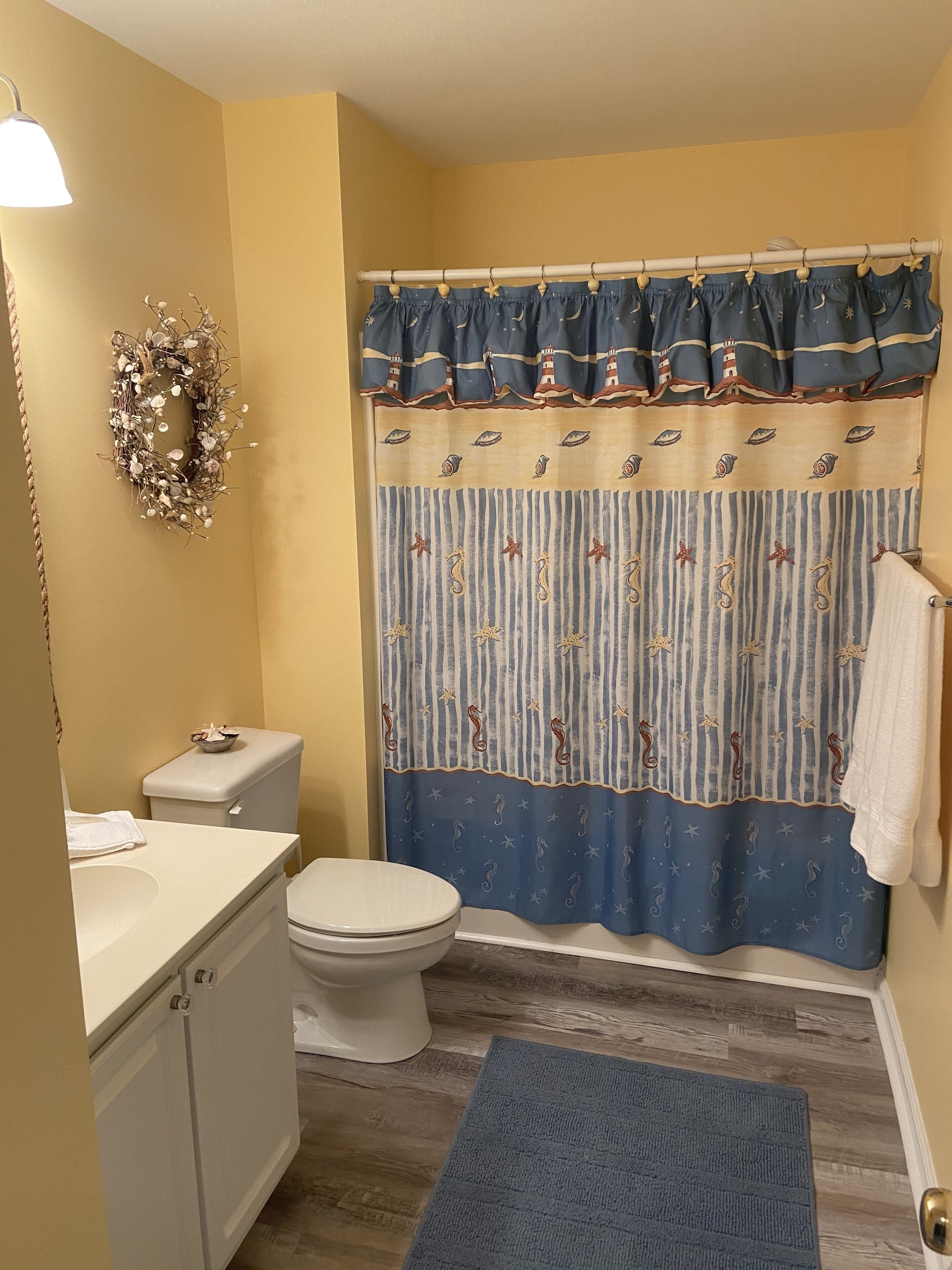 A bathroom with a toilet, sink, and shower curtain.