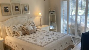 A bedroom with a bed, a ceiling fan, a nightstand, a lamp, a dresser, a mirror, and a window with blinds. - Need to get away ... Cabin fever got you down. Take a trip to Pawleys Island, SC (Pawleys Island)