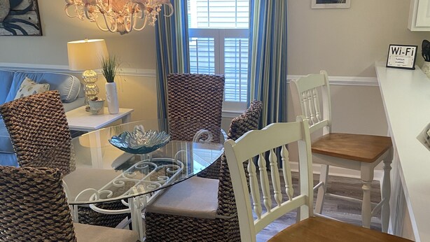 A dining area with wicker chairs, a glass table, and a chandelier. - Need to get away ... Cabin fever got you down. Take a trip to Pawleys Island, SC (Pawleys Island)