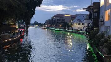A river with buildings on the right and a tree on the left.