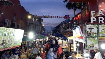 A bustling street market with various stalls and people shopping.