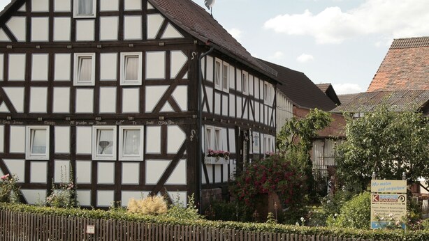 A traditional half-timbered house with multiple windows and a satellite dish. - VALUE HOF | cozy holiday house (Bracht)