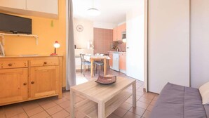 A compact living space with a kitchenette, a dining area, and a seating area.