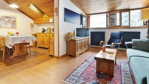 Ein gemütliches Wohnzimmer mit Holzböden, einem Essbereich und einer Küche.
