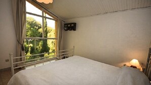 A bedroom with a large window, a bed, and a nightstand with a lamp. - Panoramic Villa with pool up to 10/12 people (Saint-Paul-de-Vence)