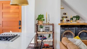 A modern kitchen with a white countertop, a stove, and a hanging light fixture. - Luxury Rental - Historic Charm - Central Location! (Charleston)