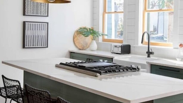 A modern kitchen with a large island, pendant lights, and bar stools. - Luxury Rental - Historic Charm - Central Location! (Charleston)