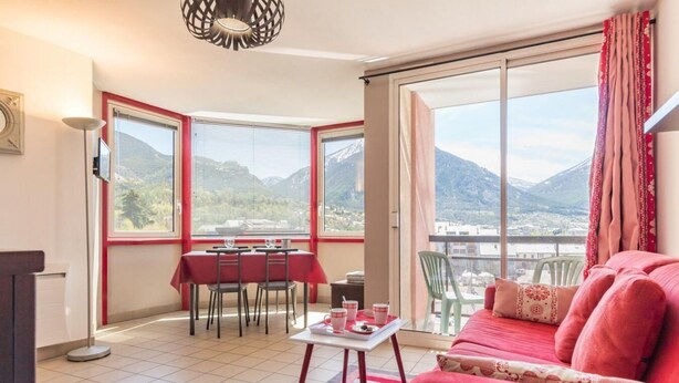 A room with a dining area, a sofa, and a view of mountains. - 150m from ski slopes, 4th floor, view mountain, balcony, tv, 31m², Serre Chevalier (Briançon)