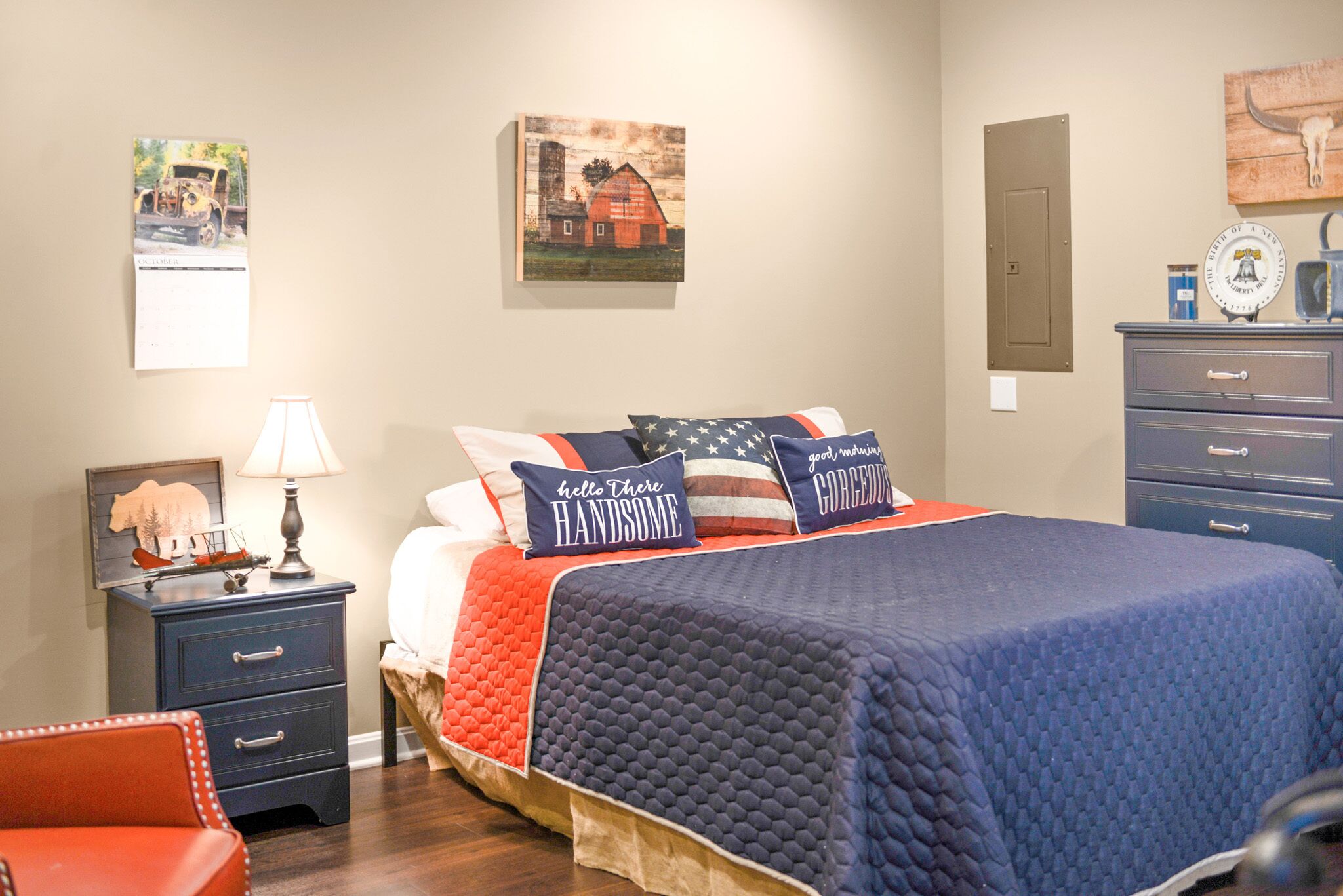 Un dormitorio con cama, mesita de noche, cómoda y lámpara.