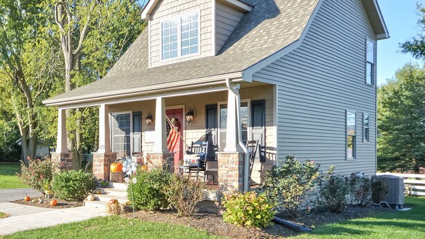 A two-story house with a front porch, a chimney, and a small garden with pumpkins. - Charming "Cream of the Crop" Cape ~❤️of Middletown (Middletown)