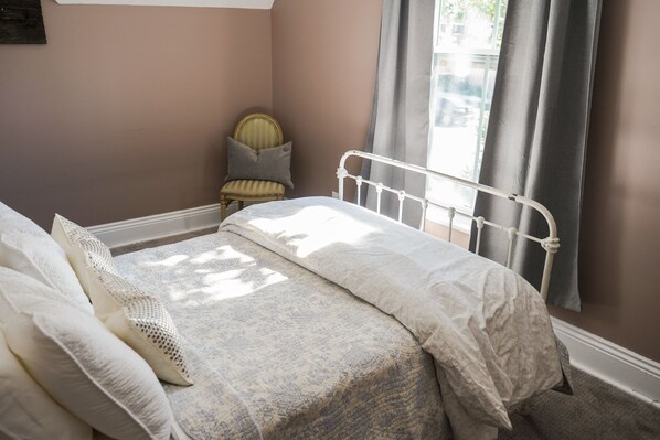 A bedroom with a bed, a chair, and a window with curtains. - Walk to Downtown or conservation area, 2 Bedroom home . Sleeps 4. Pets welcomed (Orangeville)
