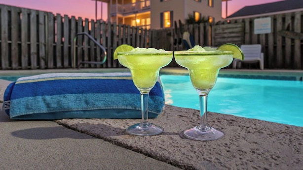 Two margaritas on a poolside with a house and wooden fence in the background. - 'BIKINI BOTTOM' OCEANSIDE OF BLVD, GREAT VIEWS,POOL, 5 Bedroom, 5 Bathrooms (Surfside Beach)