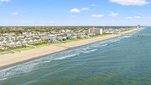 A coastal residential area with houses along the beach, a pier extending into the water, and a clear sky. - 'BIKINI BOTTOM' OCEANSIDE OF BLVD, GREAT VIEWS,POOL, 5 Bedroom, 5 Bathrooms (Surfside Beach)
