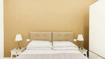 A bedroom with a beige headboard, white bedding, and two bedside lamps.