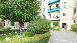 Une cour avec un chemin pavé menant à un bâtiment doté de balcons.
