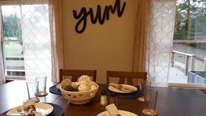 A dining table set with plates, cutlery, and a bowl of decorative items.