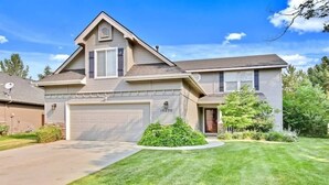 A two-story house with a garage, a well-maintained lawn, and a small garden area. - Upscale House for 17 with Firepit & Lovely Yard (Star)